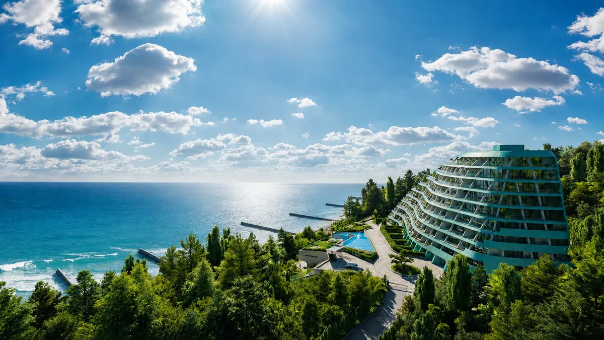 Современный террасный курорт на зелёном склоне с видом на море и бассейн.